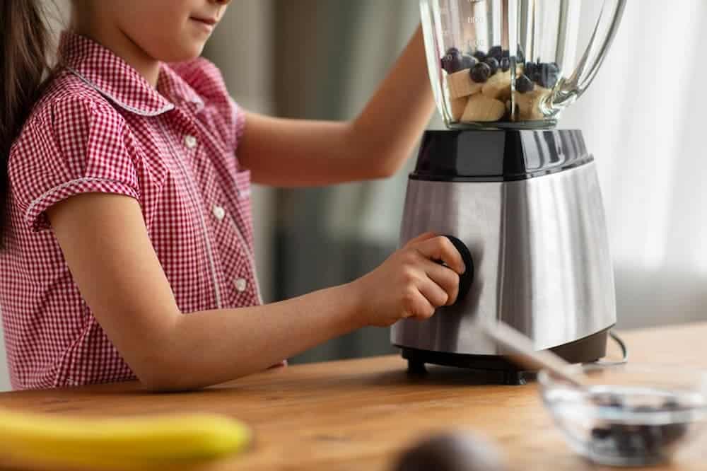 Niña usando la licuadora